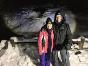 Couple at frozen waterfall at night