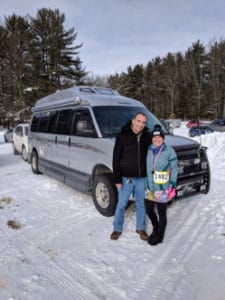 Couple with van in snowy parking lot