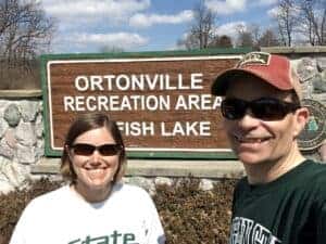 woman and man in front of state park sign