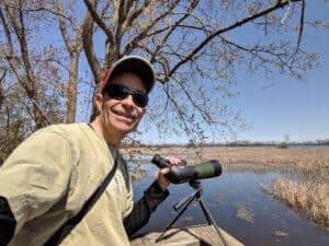 man with spotting scope in marsh