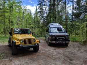 Jeep Wrangler and Class B RV in rustic campsite at Rifle River Recreation Area -- a Michigan State Park