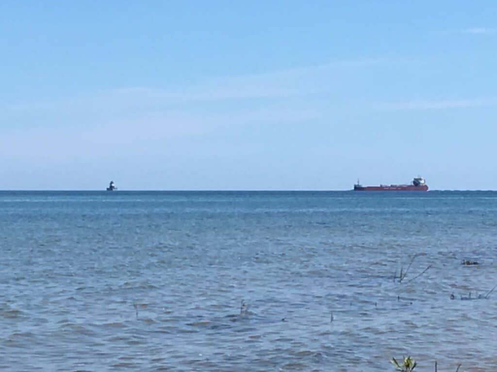 A picture of a freighter and a lighthouse in Lake Huron