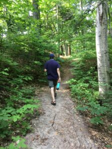 Man hiking on a trail in the woods