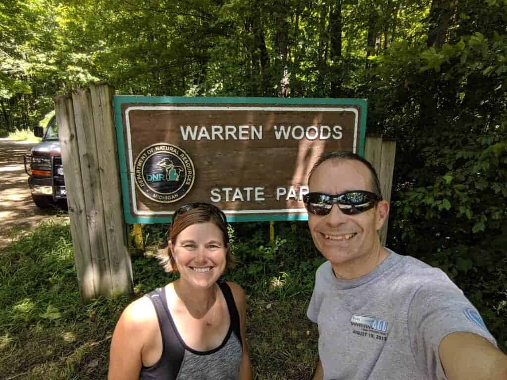 Two people by the state park entrance sign