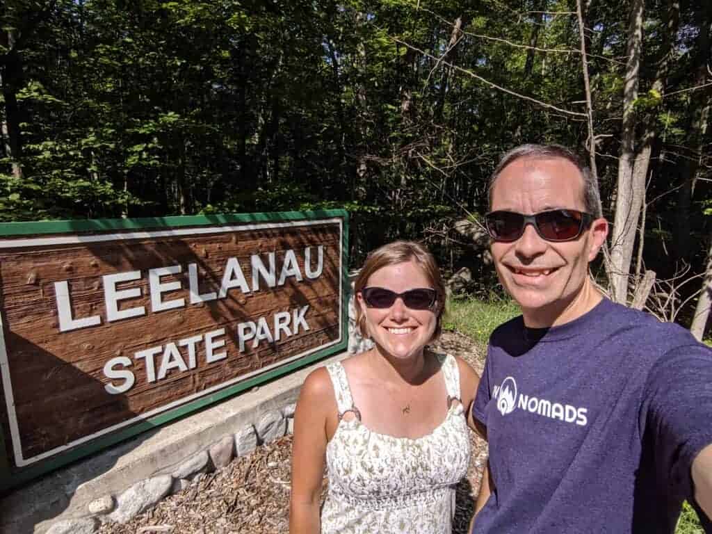 Two people by state park entrance sign