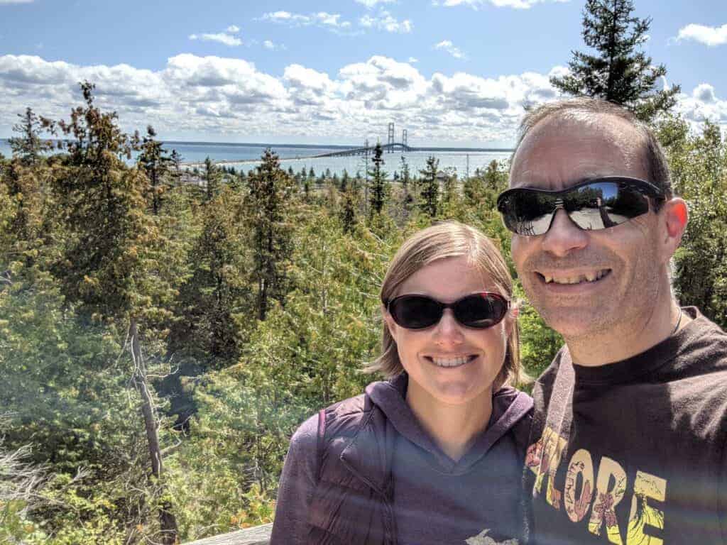 Two adults with the Mackinac Bridge behind them in the distance