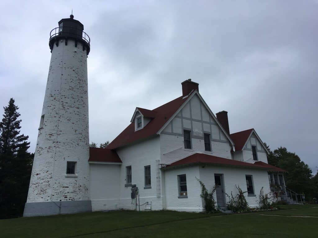 A white lighthouse and keepers building