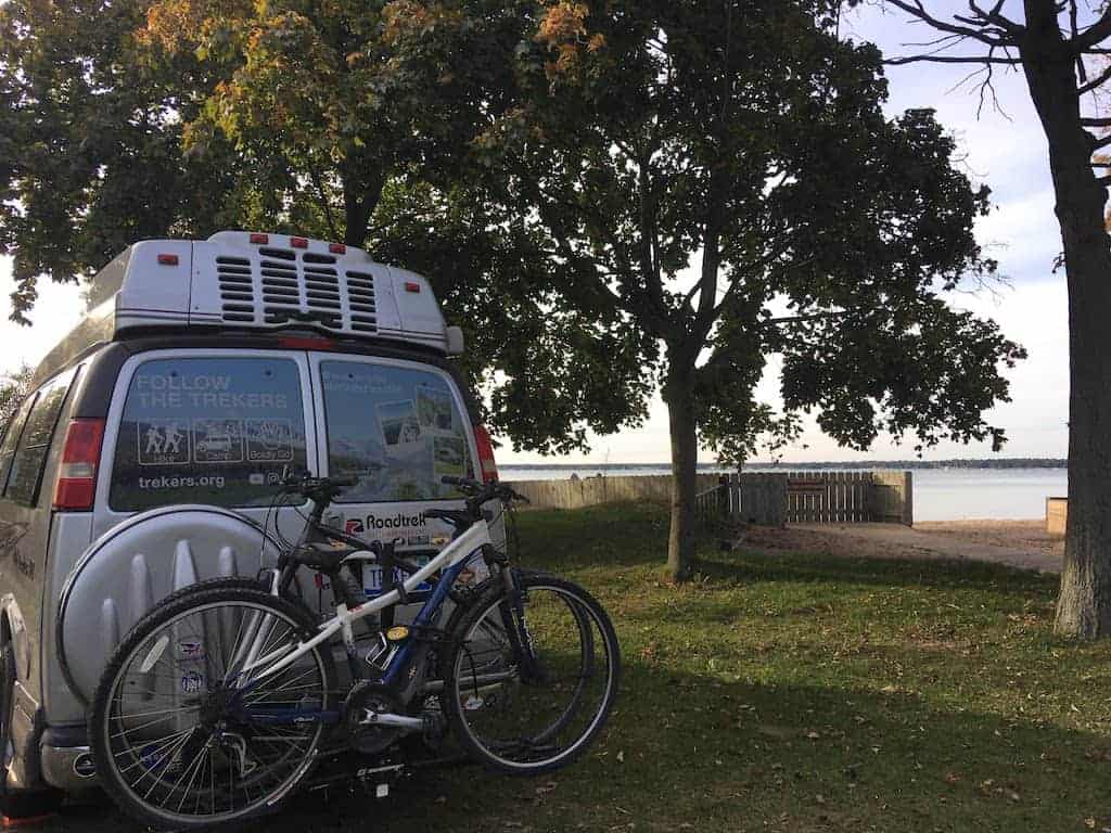 A campervan at Tawas Point State Park parked next to the water