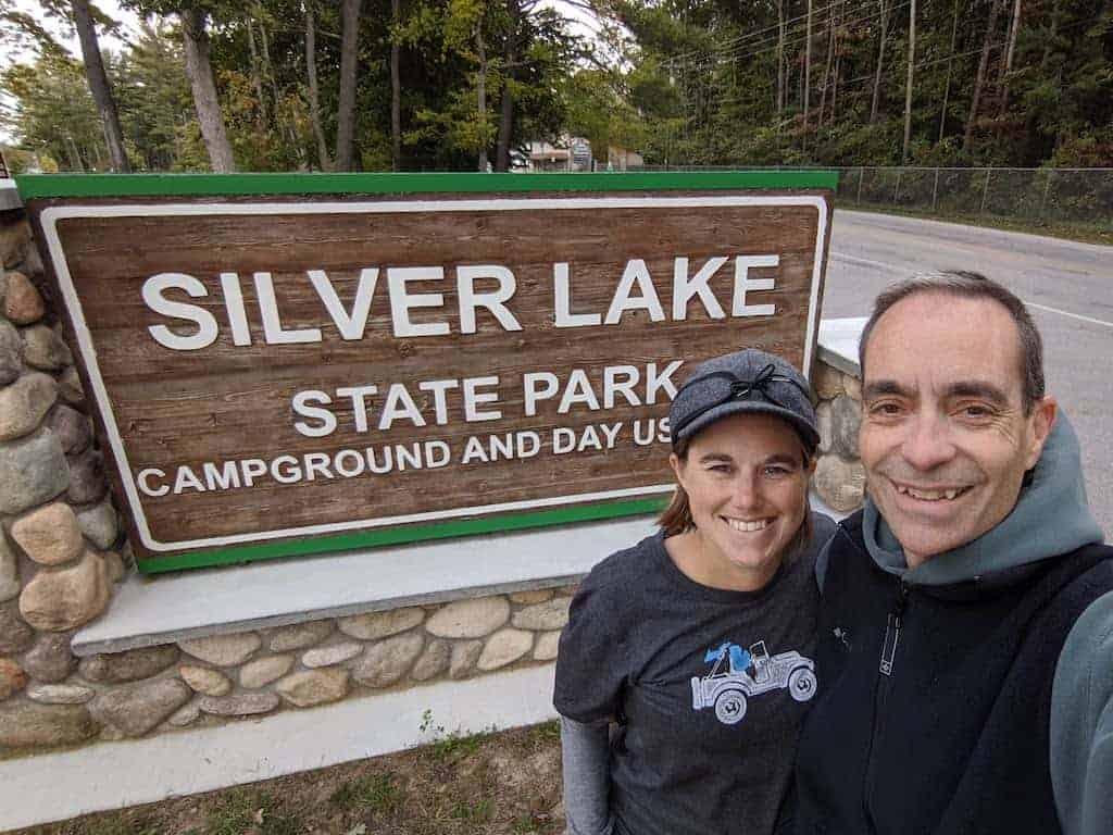 2 adults in front of the Silver Lake State Park entrance sign
